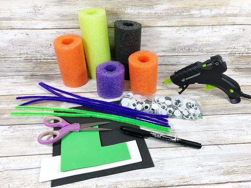 Craft foam, pipe cleaners, scissors, googly eyes, glue gun, and pieces of pool noodles for craft project.