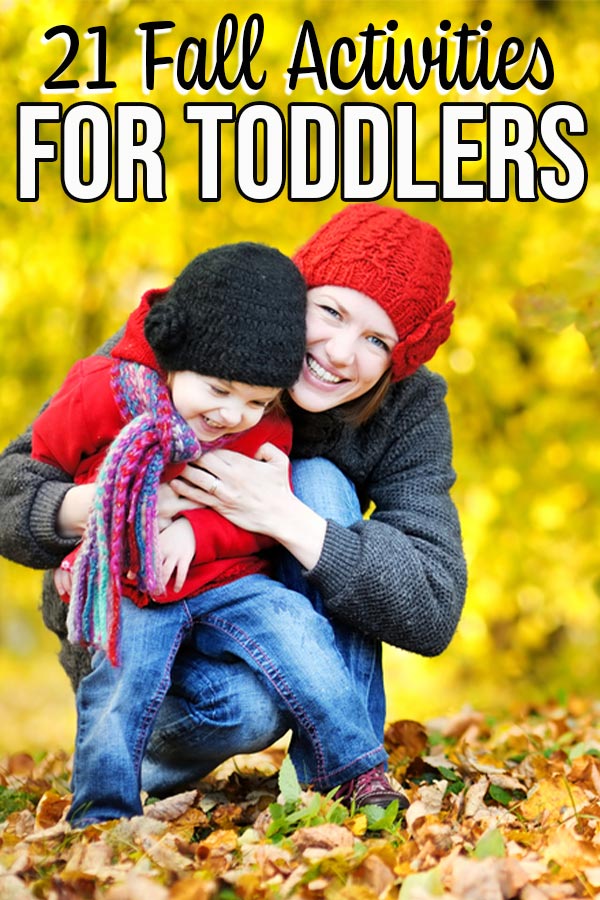 Mom hugging smiling toddler outside while kneeling in pile of leaves. Text overlay at top says 21 fall activities for toddlers.
