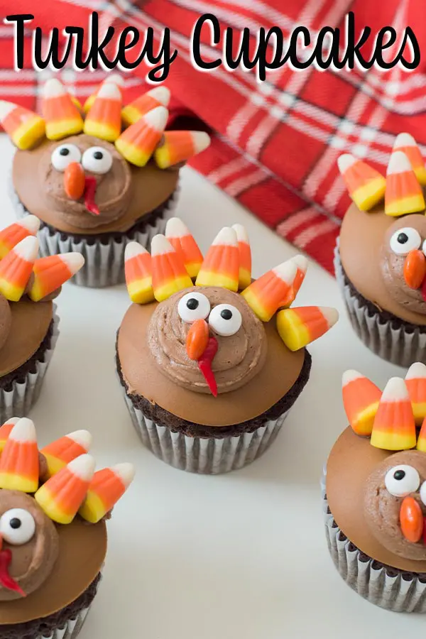 Several completed turkey cupcakes on white table with plaid kitchen towel and text overlay.