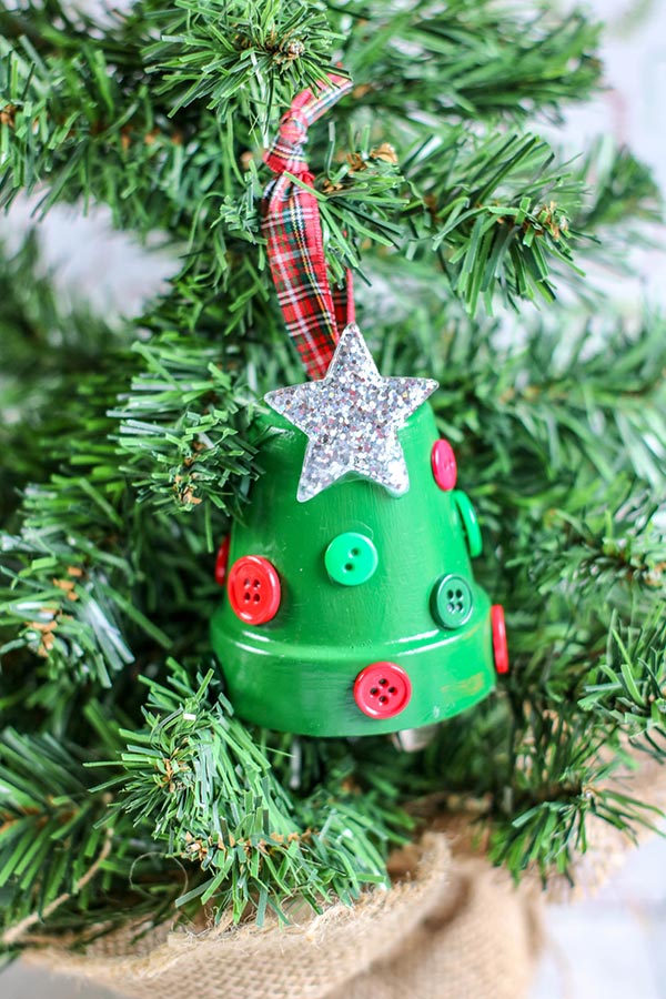 Completed Christmas tree flower pot ornament hanging from small Christmas tree.