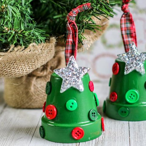 Completed clay pot Christmas Tree ornaments sitting side by side on table next to mini evergreen tree.