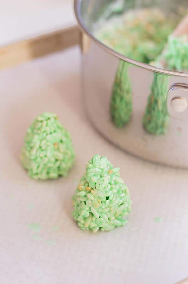 Making rice crispy treats shaped like Christmas trees.