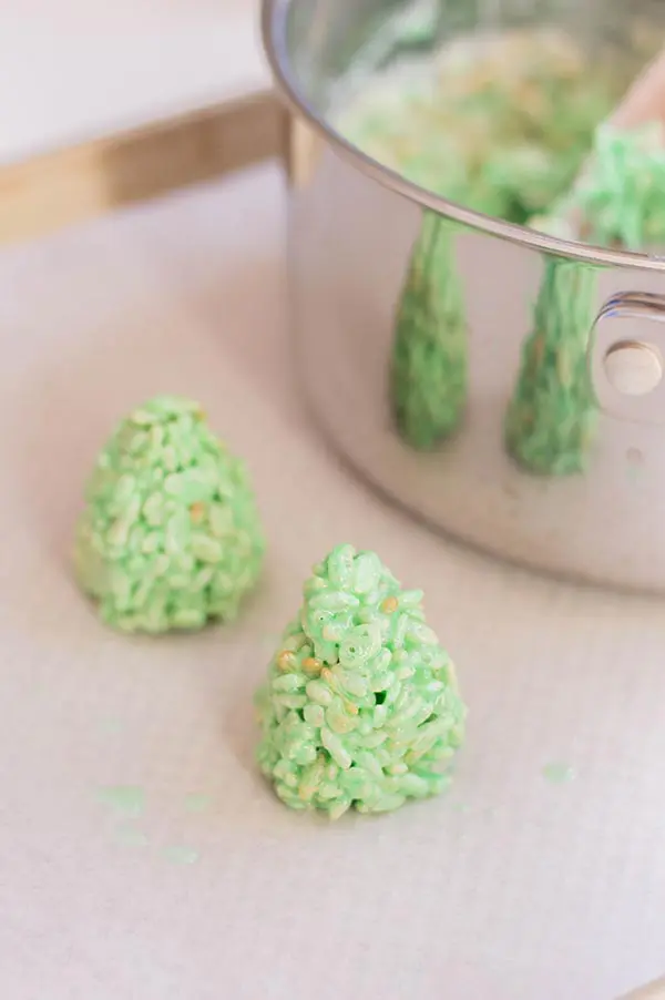 Making rice crispy treats shaped like Christmas trees.