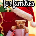 Pile of presents, teddy bear popping out of one gift, and a Santa hat on a table. Yellow bokah background and text overlay that says 25+ Holiday Gifts for families.