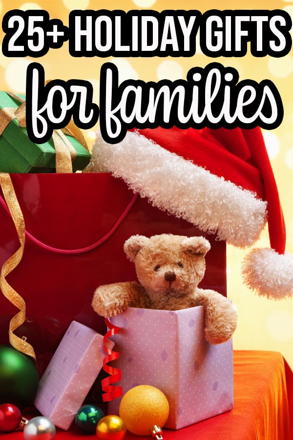 Pile of presents, teddy bear popping out of one gift, and a Santa hat on a table. Yellow bokah background and text overlay that says 25+ Holiday Gifts for families.