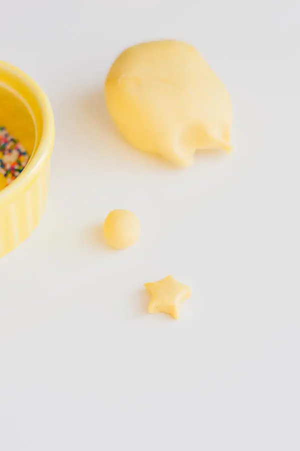 Ball of yellow fondant and another piece of fondant shaped into a star.
