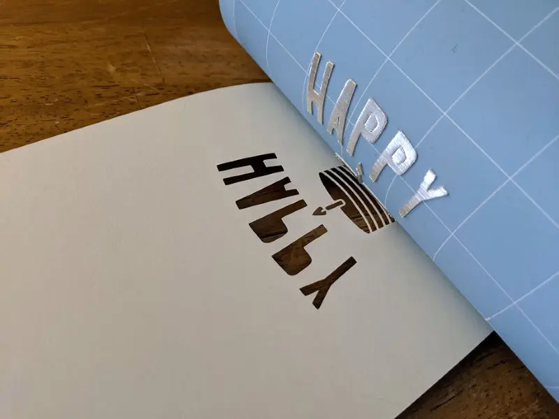 Peeling blue LightGrip cutting mat off of paper.
