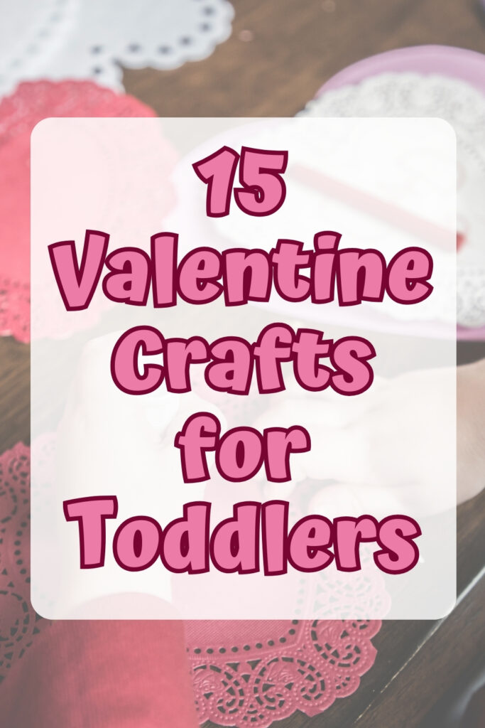 Pink text over a partially transparent white rectangle says 15 Valentine Crafts for Toddlers. Background shows little hands making a heart shaped craft.