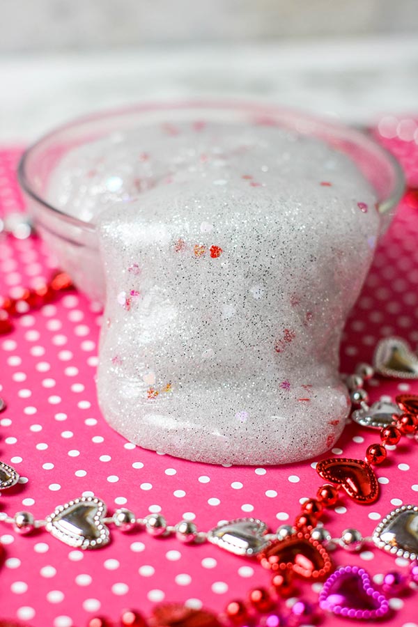 Valentine Day slime completely mixed and pouring over the side of a small bowl.