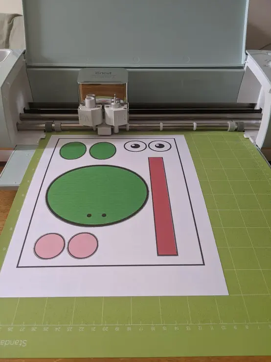 Frog template printed on cardstock and on mat in Cricut cutting machine.