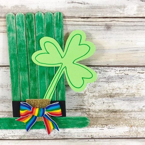 Overhead view of green top hat made with popsicle sticks and decorated with a paper shamrock.