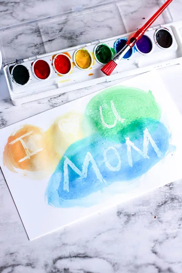 Painting with watercolors over white crayon reveals message or design.