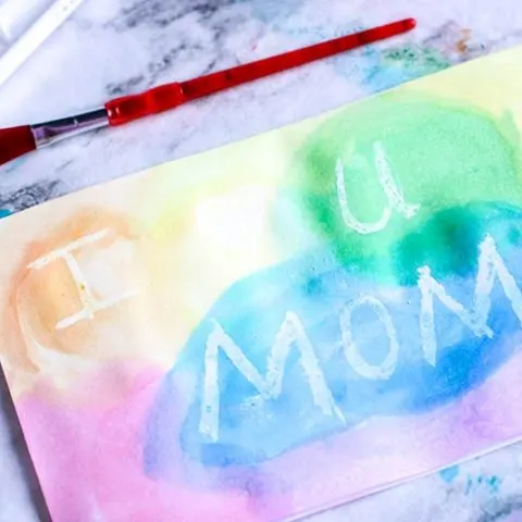 Finished watercolor resist Mother's Day card with multiple colors painted on front. Message says I heart U Mom
