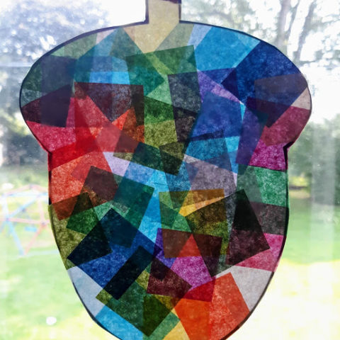 Acorn suncatcher made with tissue paper on window.