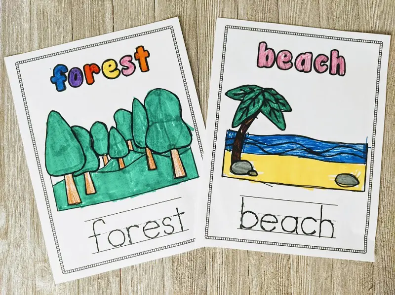 Forest and beach biome coloring pages colored with markers laying on a wooden background.
