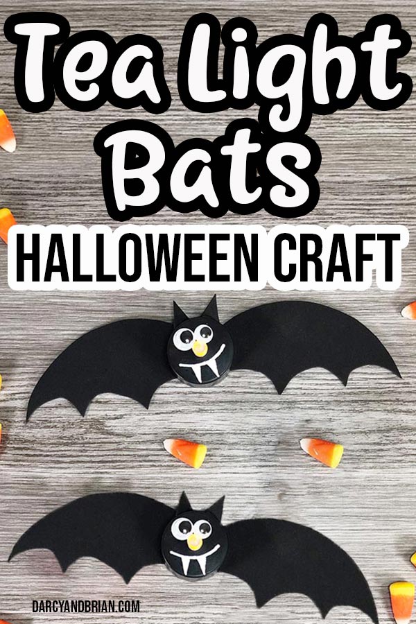 Two completed bats made with black flameless tea light candles on a gray wooden background with candy corn sprinkled around them. Text at top says Tea Light Bats Halloween Craft