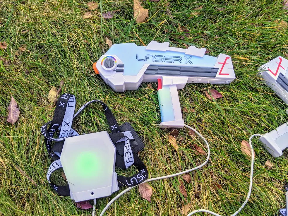 Laser X Revolution blaster with green light on health indicator. Blaster laying in grass outside.
