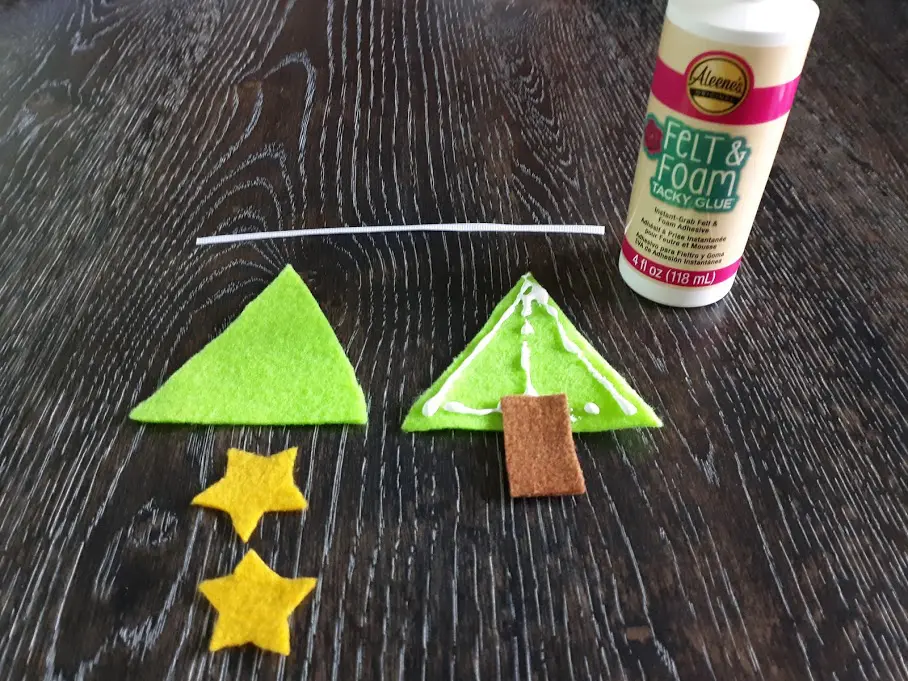Felt Christmas tree craft tutorial step showing where to glue the stump on the triangle.