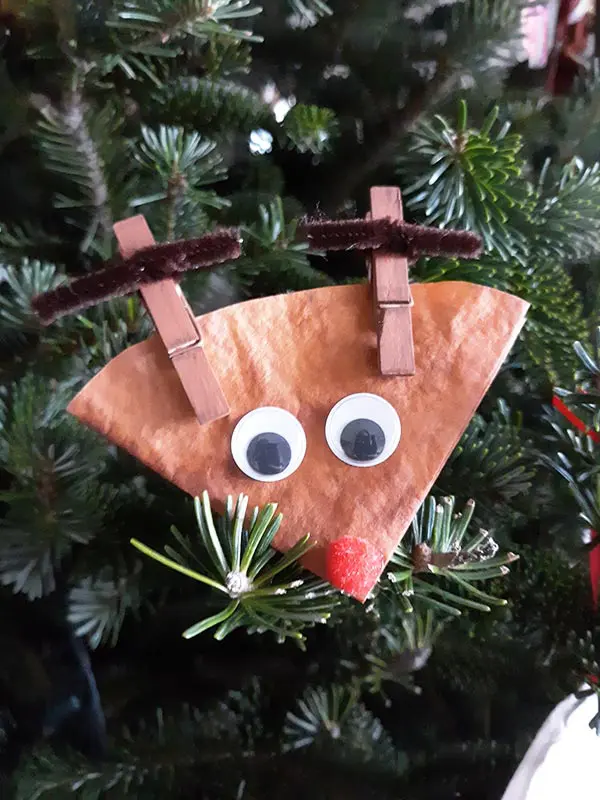 Close up of finished coffee filter reindeer craft displayed on Christmas tree.
