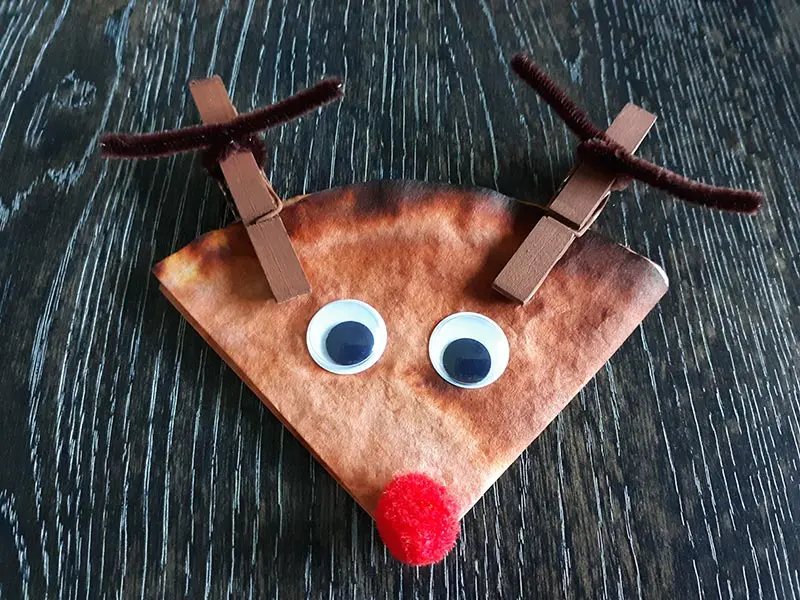 Completed coffee filter reindeer craft with googly eyes and clothespin antlers.