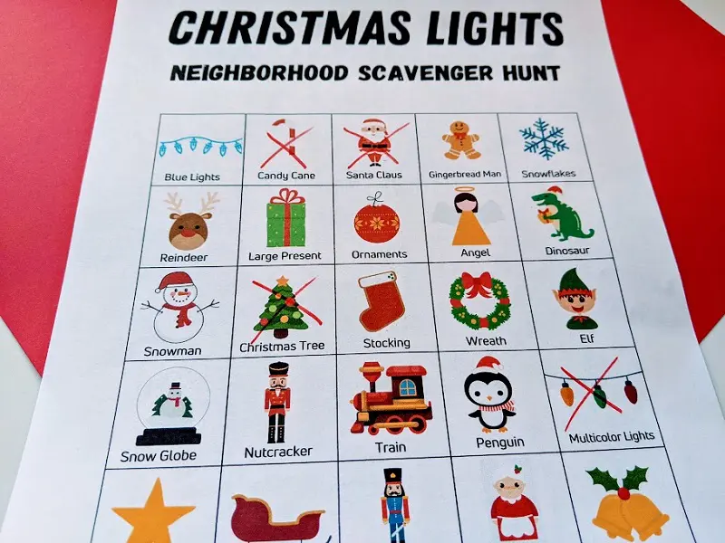 Close view of Christmas lights picture scavenger hunt page printed out with four different boxes crossed out with red marker.