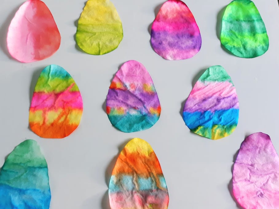Overhead view of ten completed coffee filter Easter eggs in a variety of colors and designs.