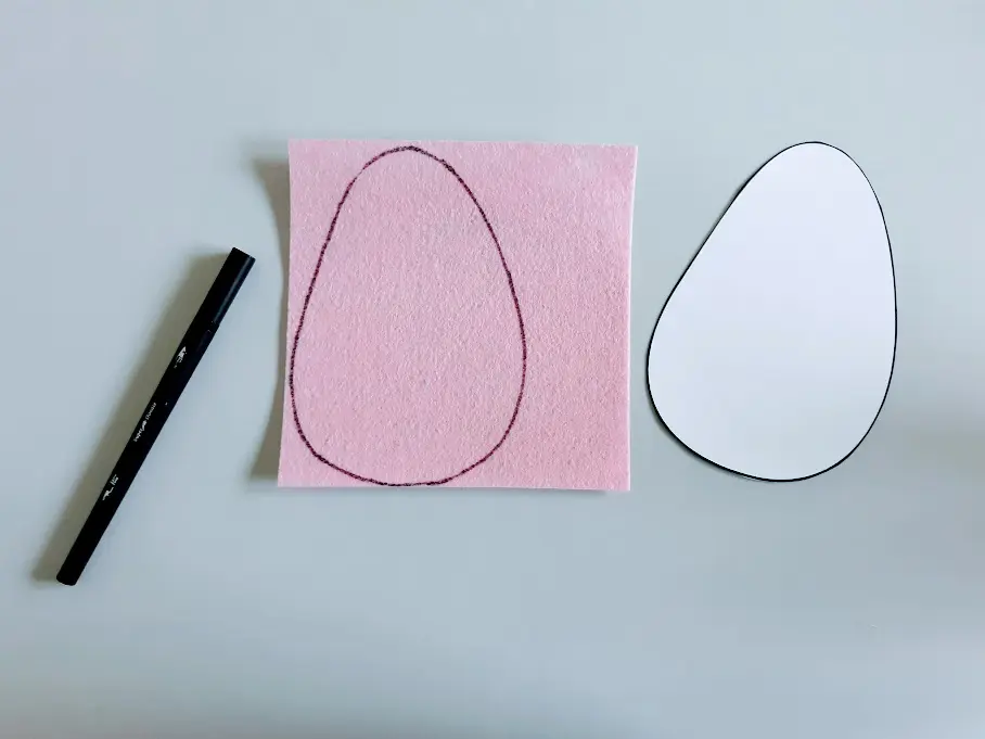 Egg template cut out and traced on a pink felt square.