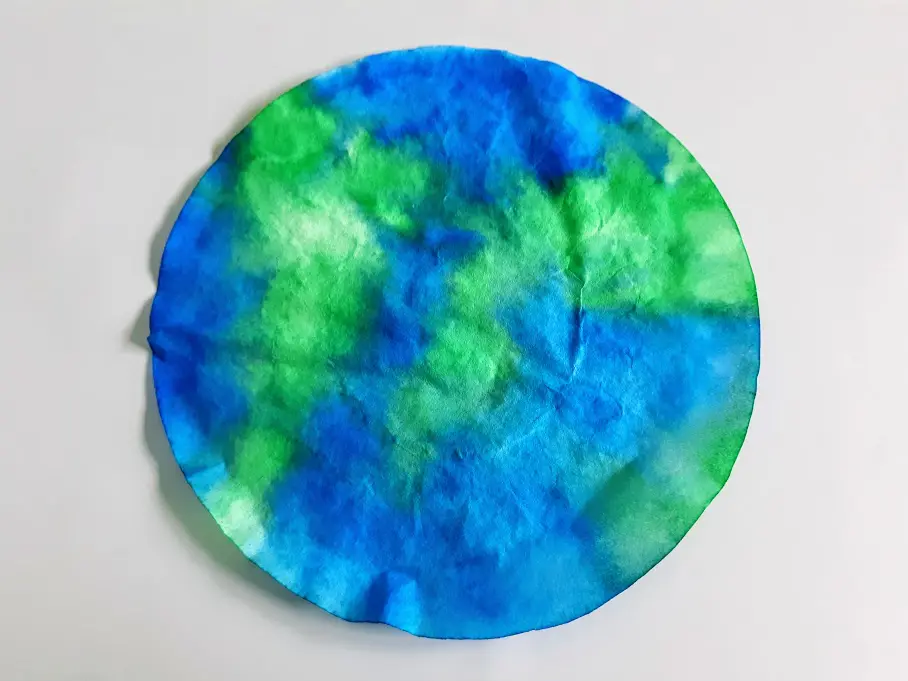 Dry coffee filter colored green and blue like Earth.