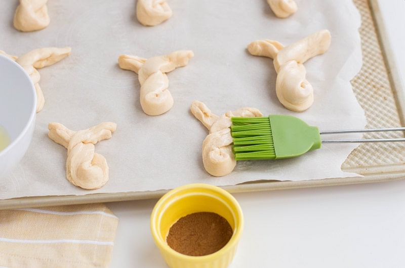 Green silicone basting brush used to egg wash bunny dough twists.