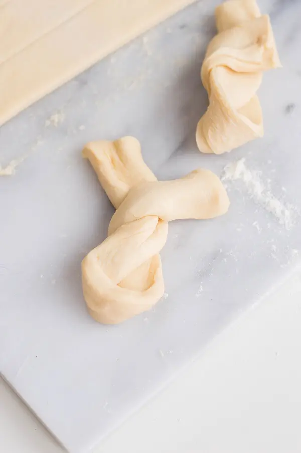 Close view of strip of dough twisted around twice to create a bunny shape.