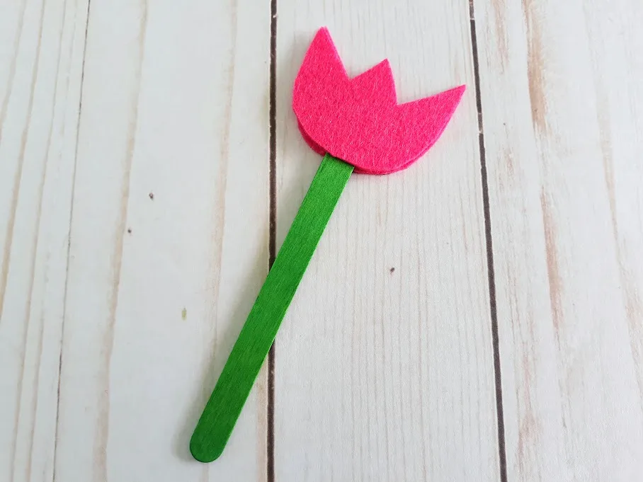 Pink felt tulip glued to a green craft stick.