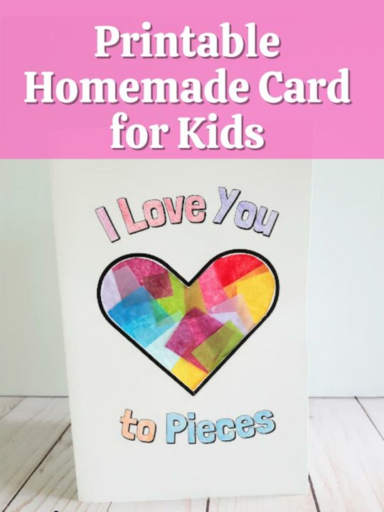 White text over light pink rectangle at top of image reads Printable Homemade Card for Kids. White cardstock folded to create a card is standing up. The words on the front of the card say I Love You to Pieces and are colored in. The heart in the center is decorated with overlapping colors of tissue paper.