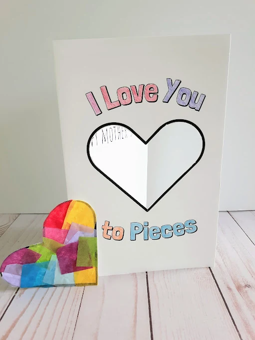 I Love You to Pieces card printed out and colored in standing up with small heart suncatcher laying next to it.