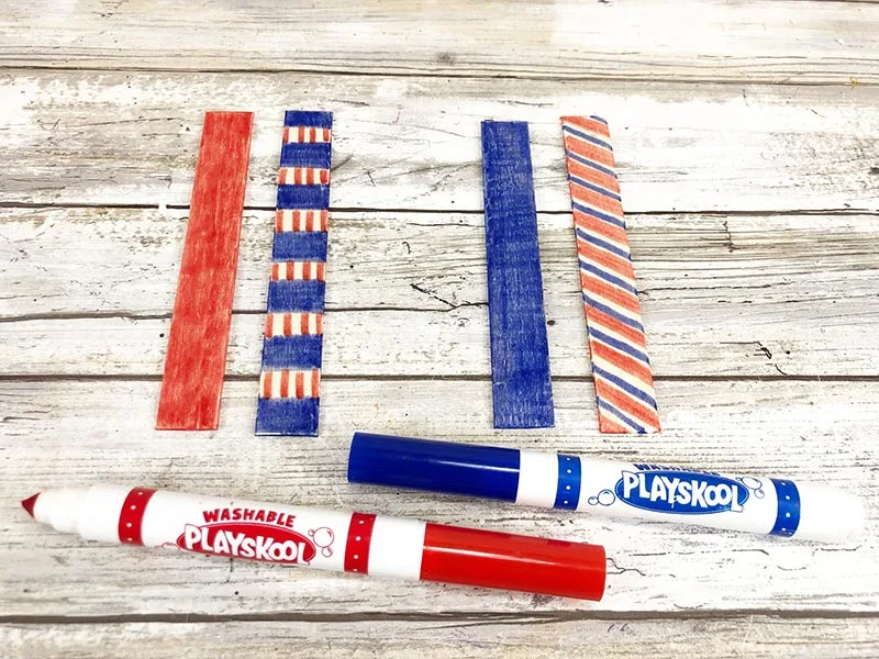 Four craft sticks with rounded ends cut off colored with red and blue markers.