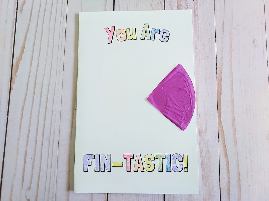 Purple cupcake liner fish tail glued to fish pun card.