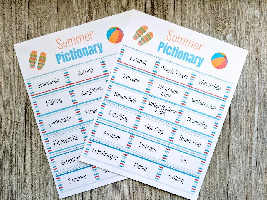 Two pages of summer pictionary game printed out and laying overlapping on a gray wooden table.