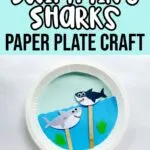 White and black text on light blue background at top says Swimming Sharks Paper Plate Craft. Below text is a photo of a completed craft using a paper plate as a backdrop and decorated to look like the ocean and two paper shark puppets on popsicle craft sticks move around through slit in the plate.