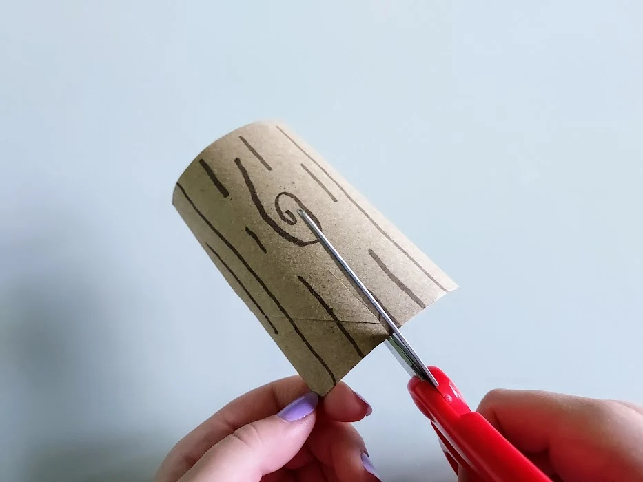 Cutting slit into cardboard tube log.