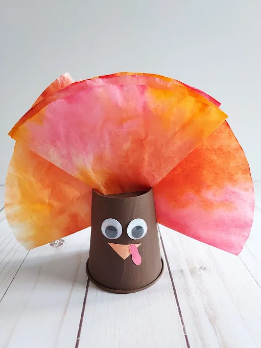 Turkey made out of painted paper cup and colored coffee filters.