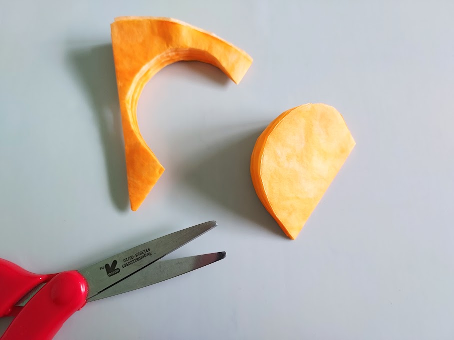 rounded pumpkin shape cut out of orange folded coffee filter