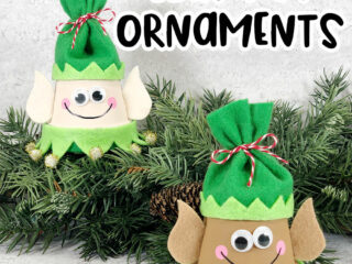 Black text at top reads Elf Clay Pot Ornaments. Black text at bottom reads Christmas Craft for Kids. Two finished elf clay pot crafts arranged by a garland of evergreen. One elf is painted with lighter skin tone and one is painted with darker skin tone. They are wearing green felt hats.