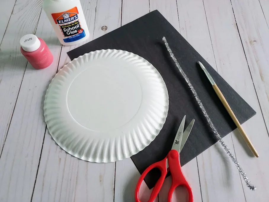 Red paint, glue, paper plate, black construction paper, silver chenille stem, pencil and scissors for making a love bug.