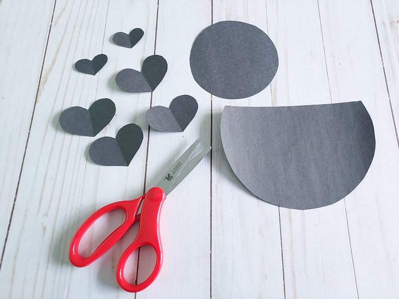 Pieces cut out of black construction paper to make love bug.
