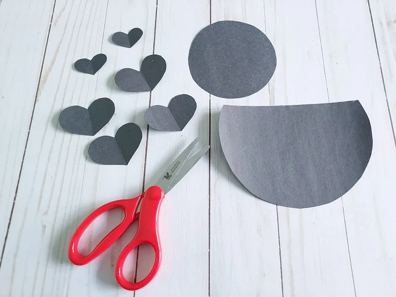 Pieces cut out of black construction paper to make love bug.