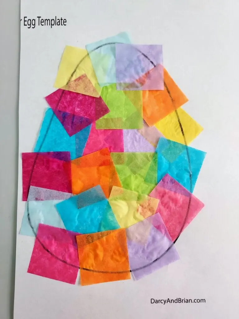 Easter egg template completely covered with glued on tissue paper squares in bright colors.