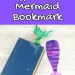 White text outlined in black on purple background at top says Coffee Filter Mermaid Bookmark. Shows a green mermaid tail sticking out of a closed hardcover book without a dust jacket. A finished purple and pink mermaid tail book mark lays next to it.
