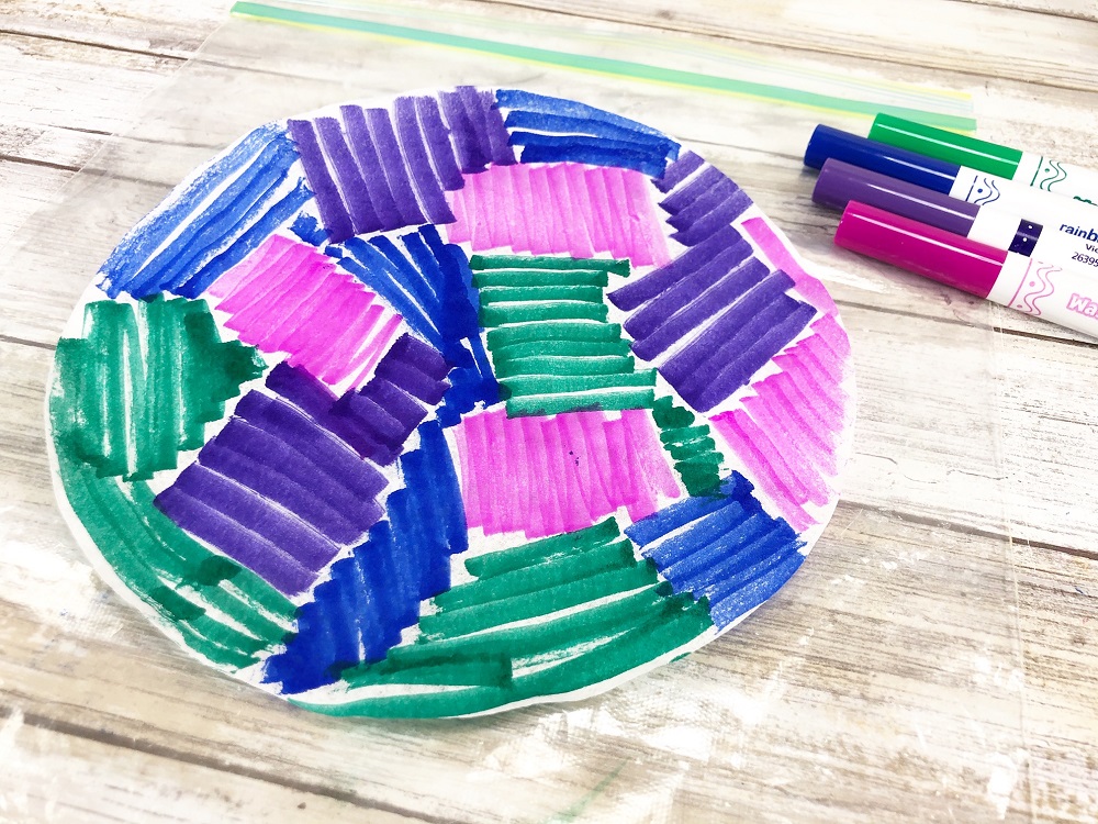 Coffee filter colored with green, blue, pink, and purple washable markers.