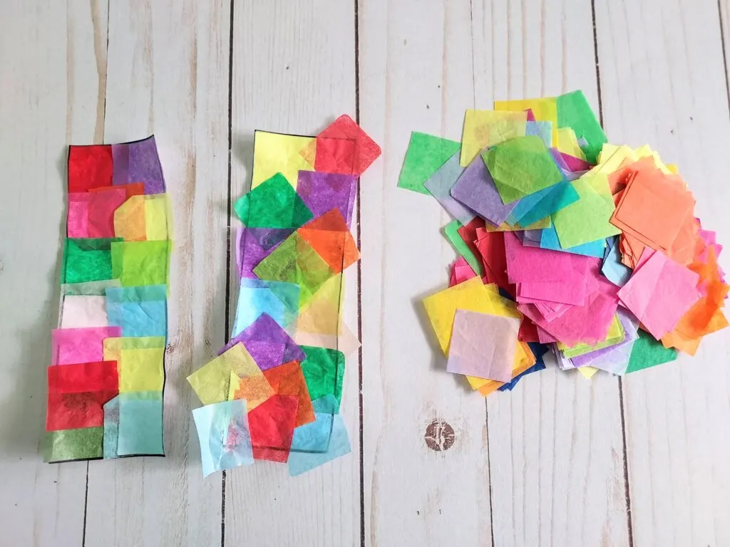 Two bookmarks laying on table next to each other with a pile of tissue paper squares off to the side. Left bookmark has been trimmed and shows the difference next to the bookmark with pieces of tissue paper hanging over the sides.