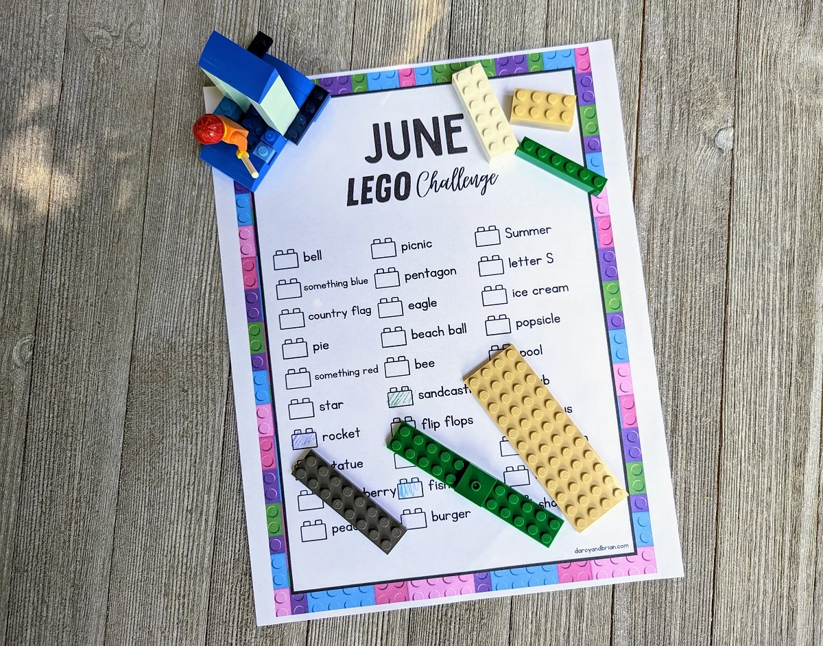 Overhead view of June LEGO build ideas printed out. A couple bricks are colored in. LEGO bricks are laying on different parts of the printable page.