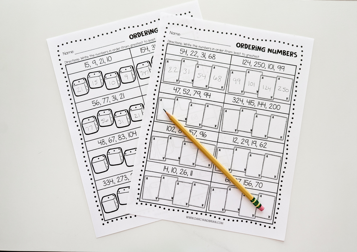 Two printed out worksheets showing some of the number order answers filled in. A pencil is laying diagonally across the paper.